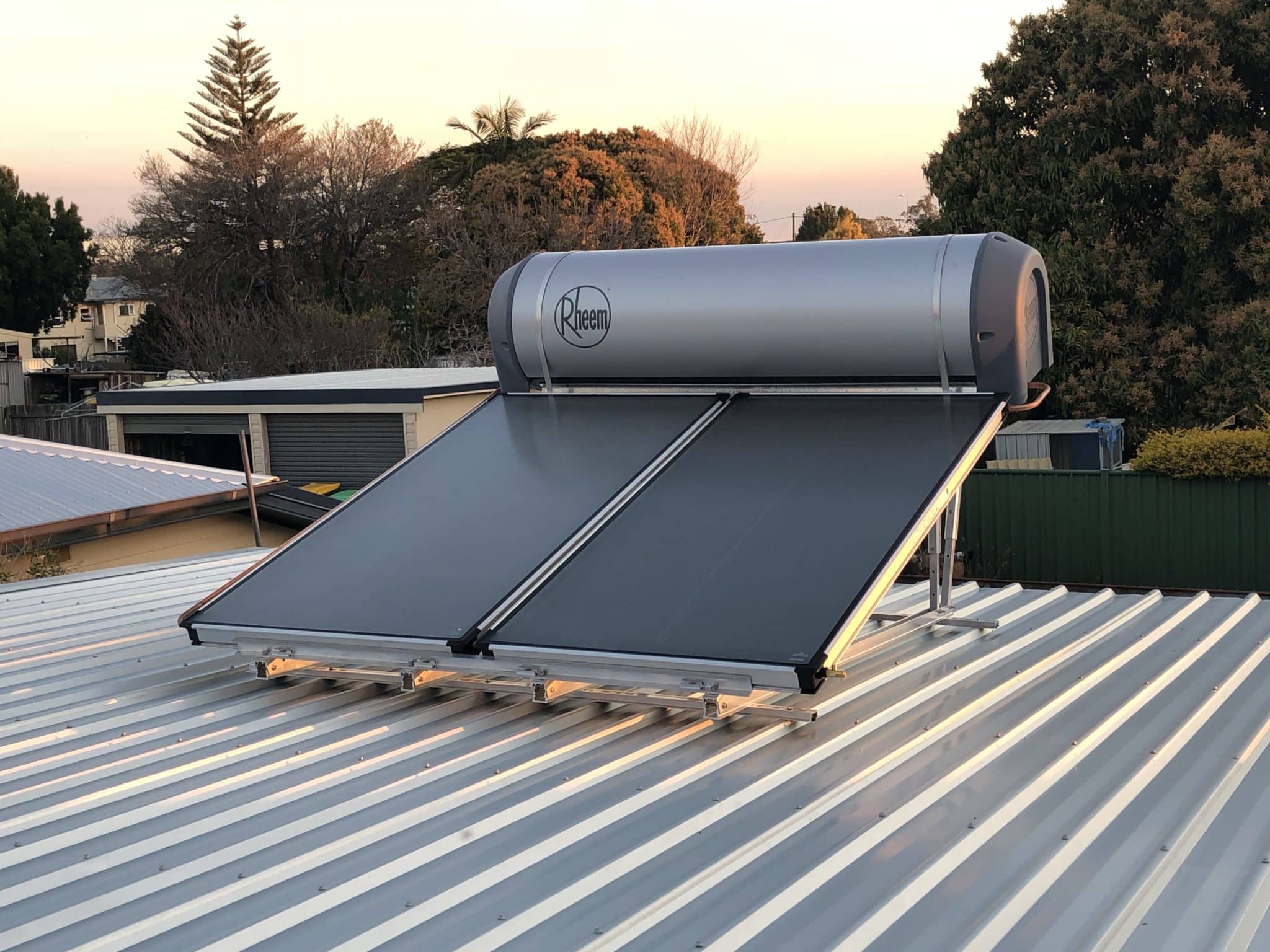 Rheem solar hot water system installed on a Ballina roof at sunset